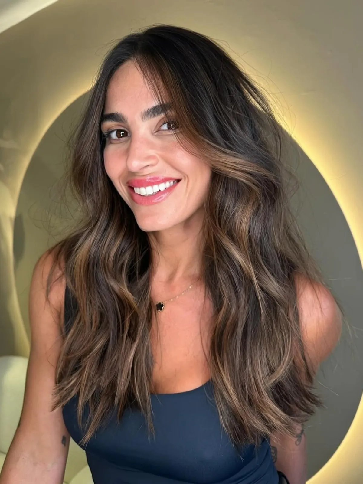 Subtle caramel highlights woven through dark brown hair for a soft, natural glow.