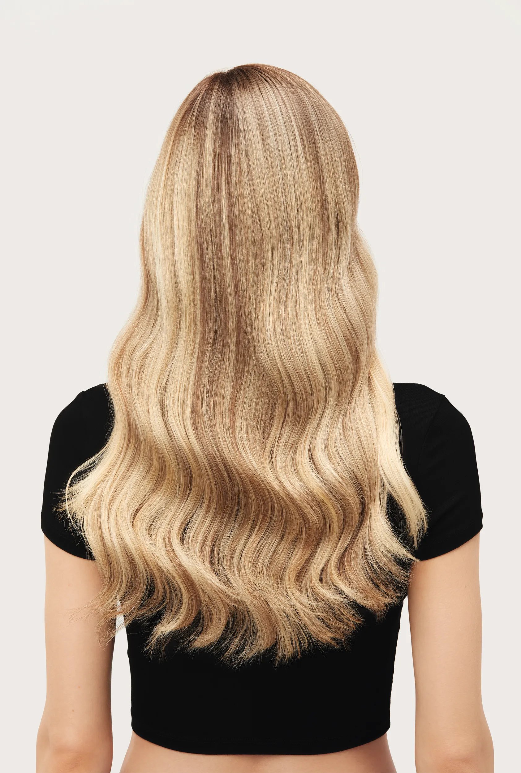 Model with short blonde long hair faces away from the camera. Hair looks fresh, healthy.