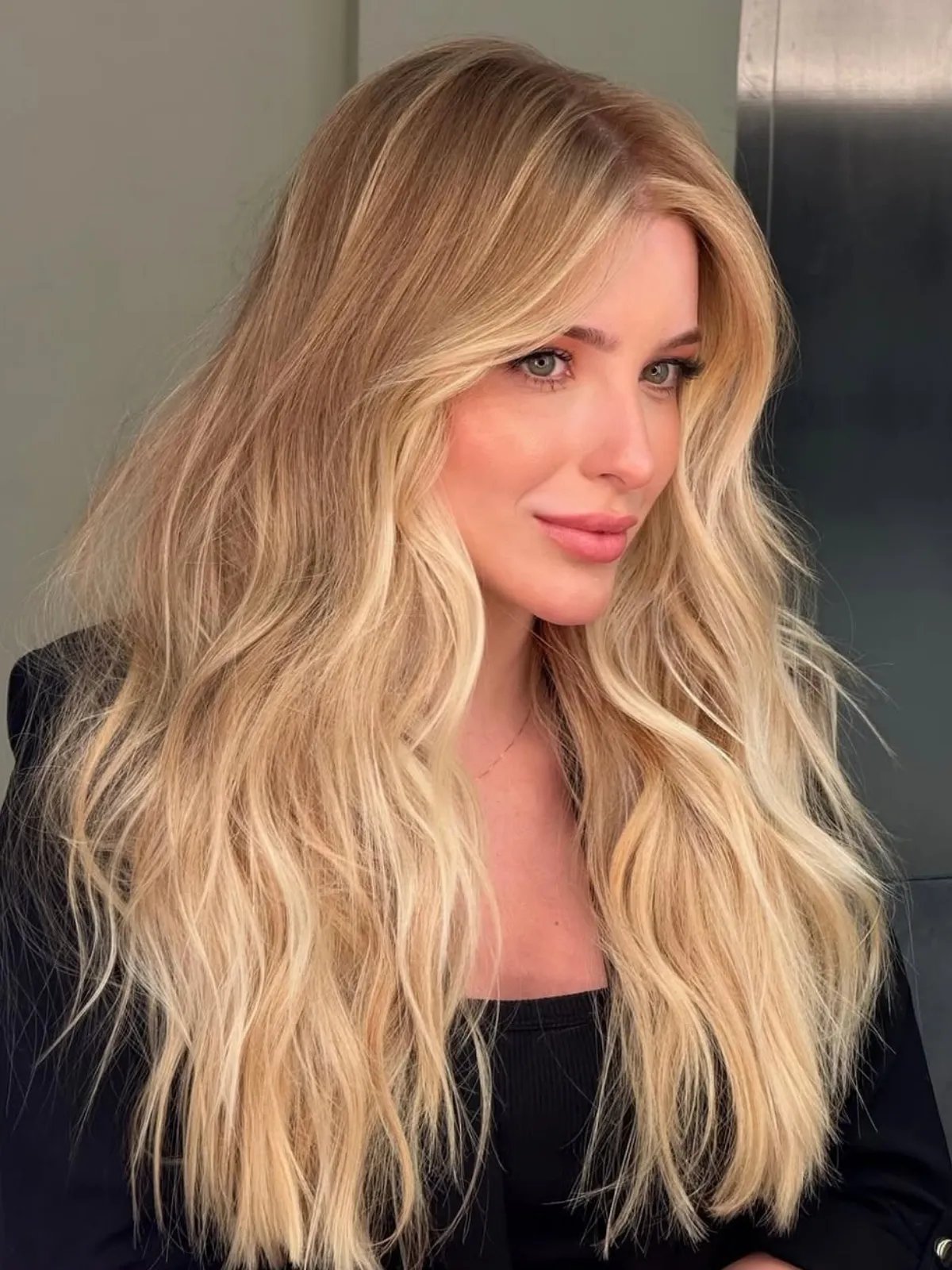 Model with long, wavy, butter blonde balayage hair.