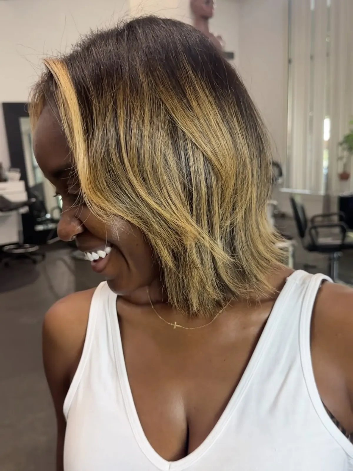 Dark brown hair with bold caramel face-framing highlights and a soft balayage.
