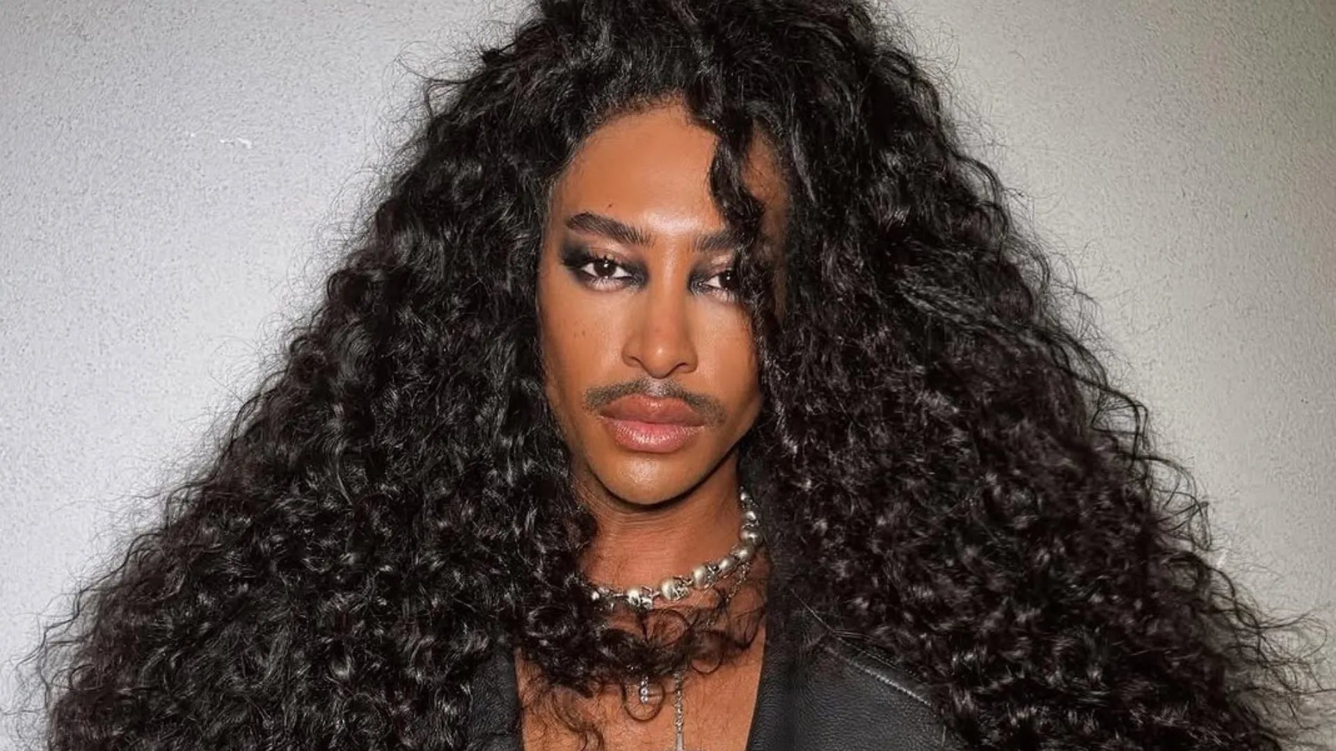 Model with long, dark brown, glossy curls.