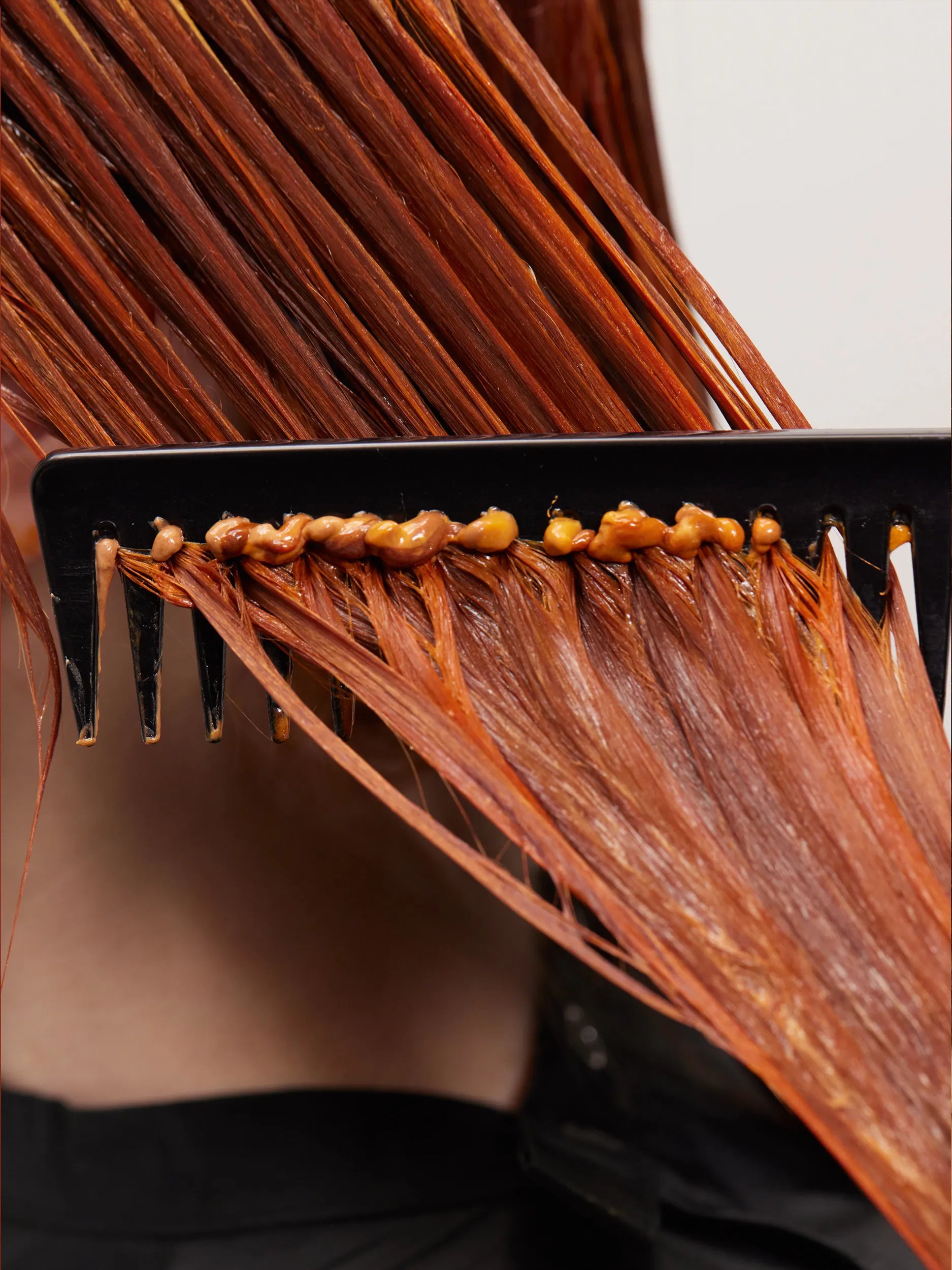 Red hair being colored and combed