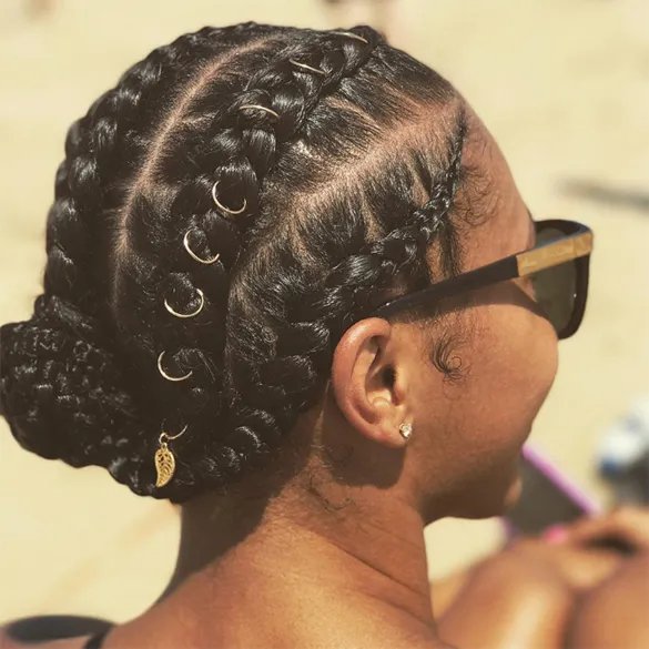 Back of woman's head with braided hair and rings.
