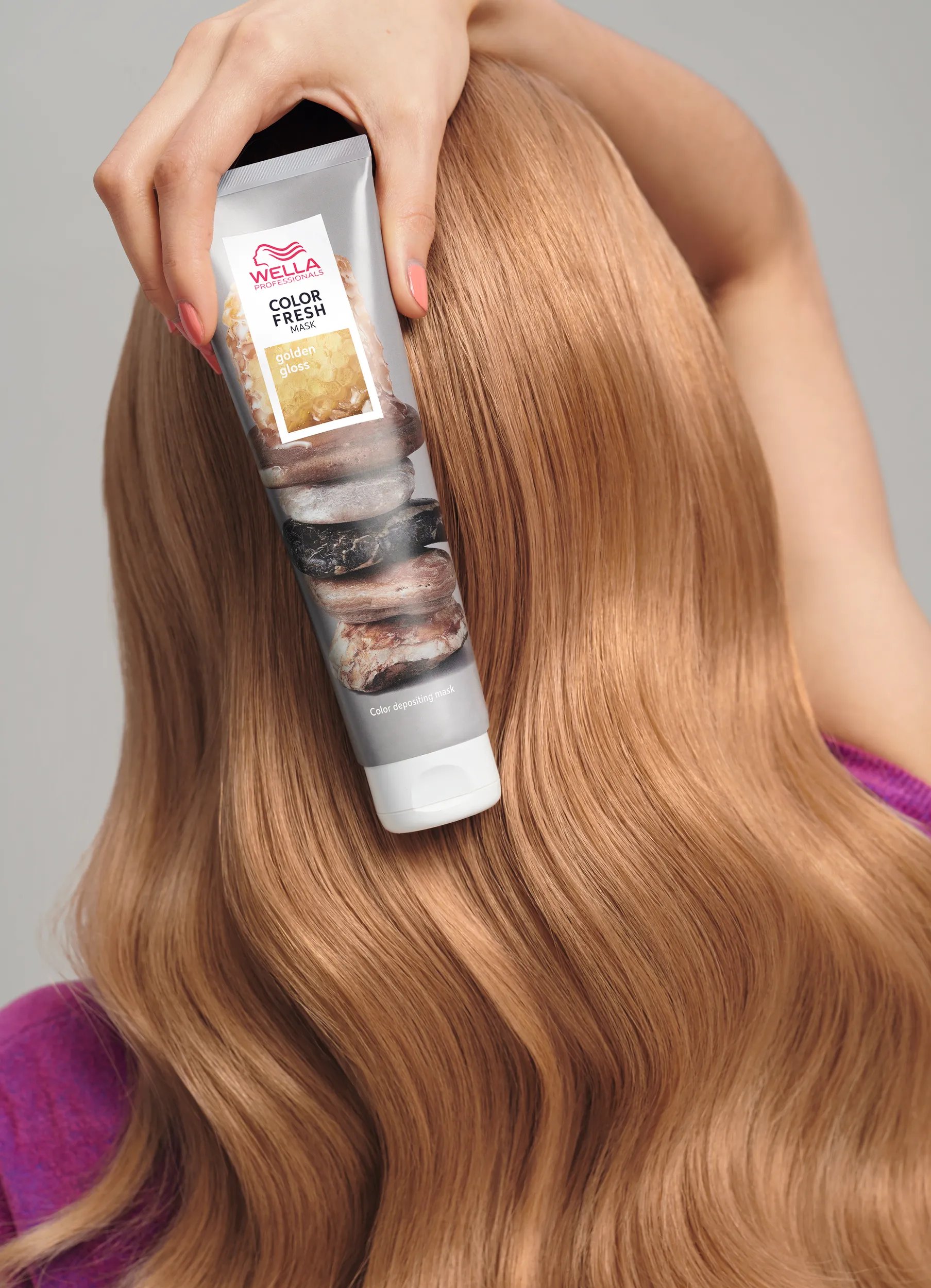 Close-up of the back of a woman’s head, as she holds up a tube of the Color Fresh Mask.