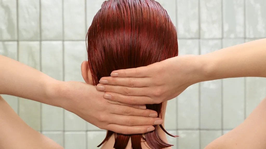 Model smooths their hands through their damp, red hair.