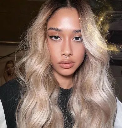 Model with long, blonde hair styled in loose, glossy waves.