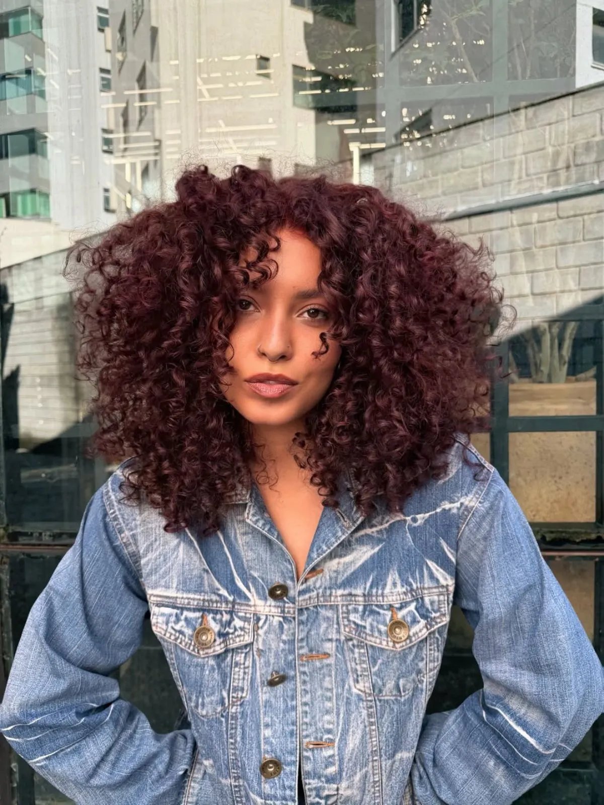 Model with full, voluminous, cherry cola red curls.