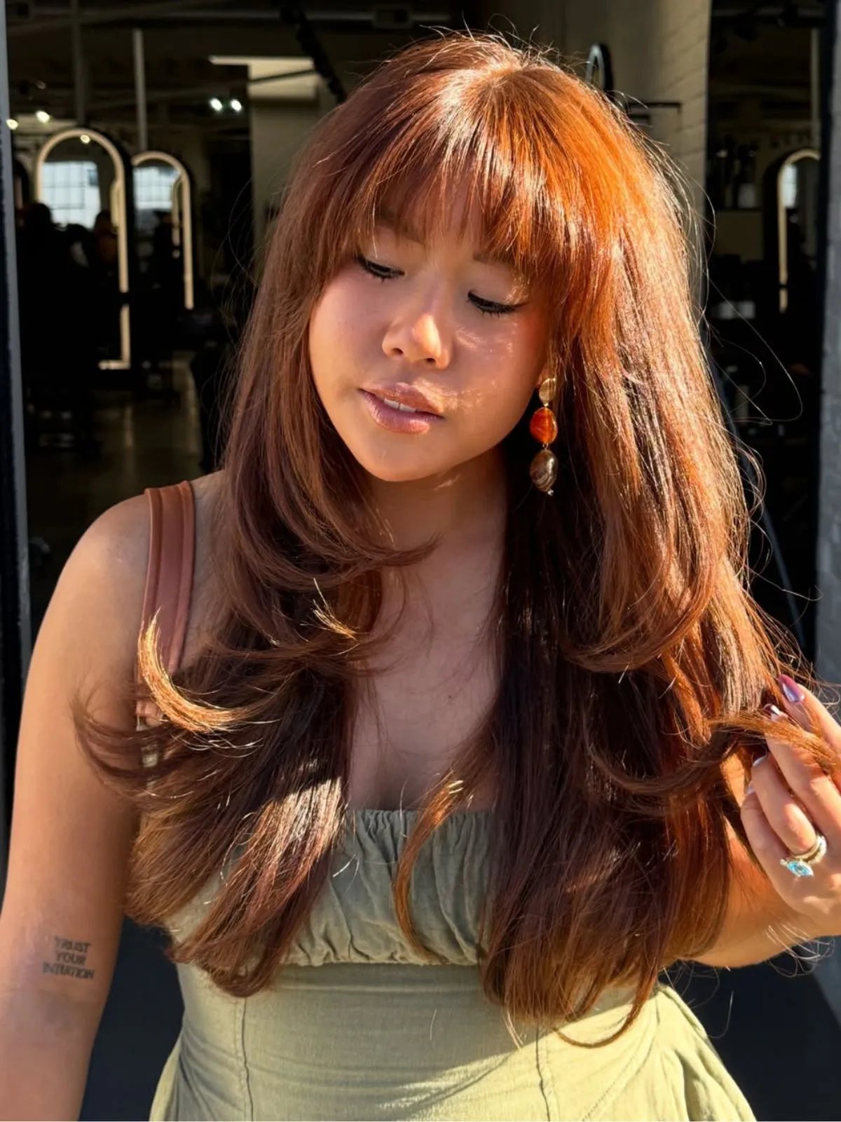 Model with long auburn hair featuring hints of apricot.