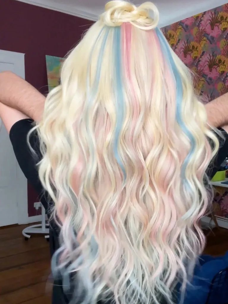 Model’s long, blonde hair features pastel pink and blue tones to symbolize the Transgender flag.