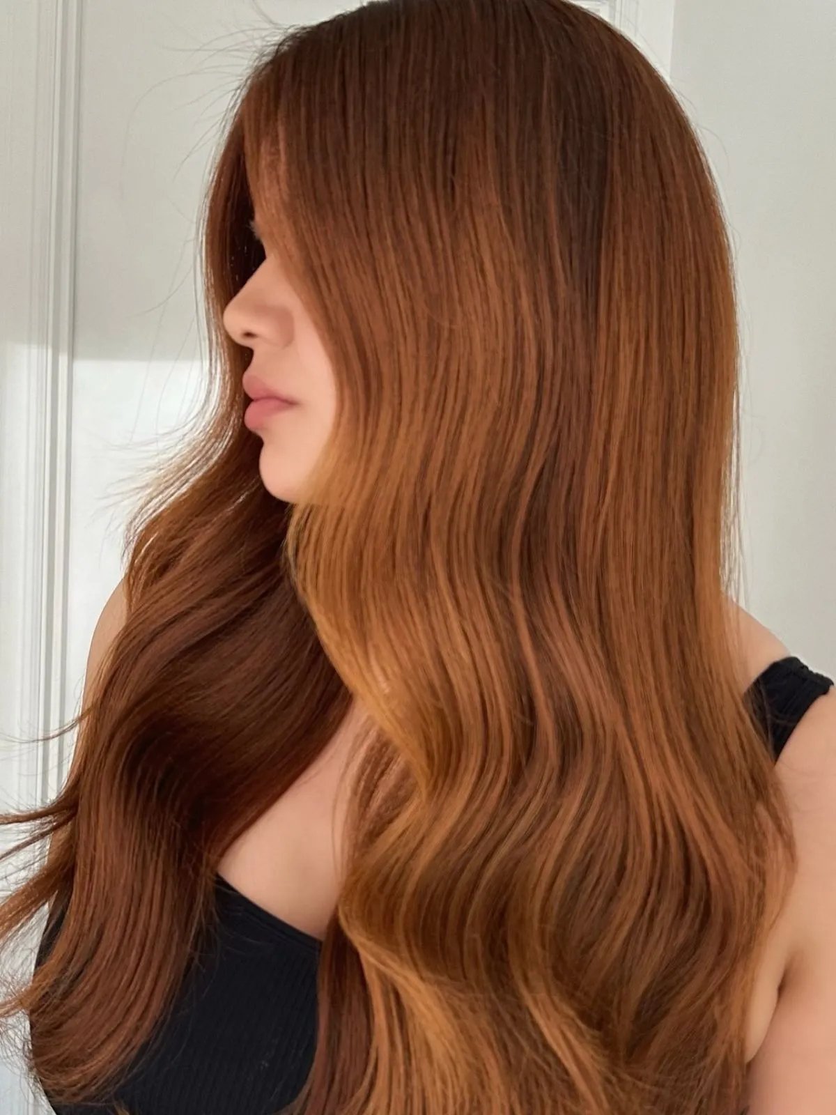 Model with long, copper hair styled in polished waves.
