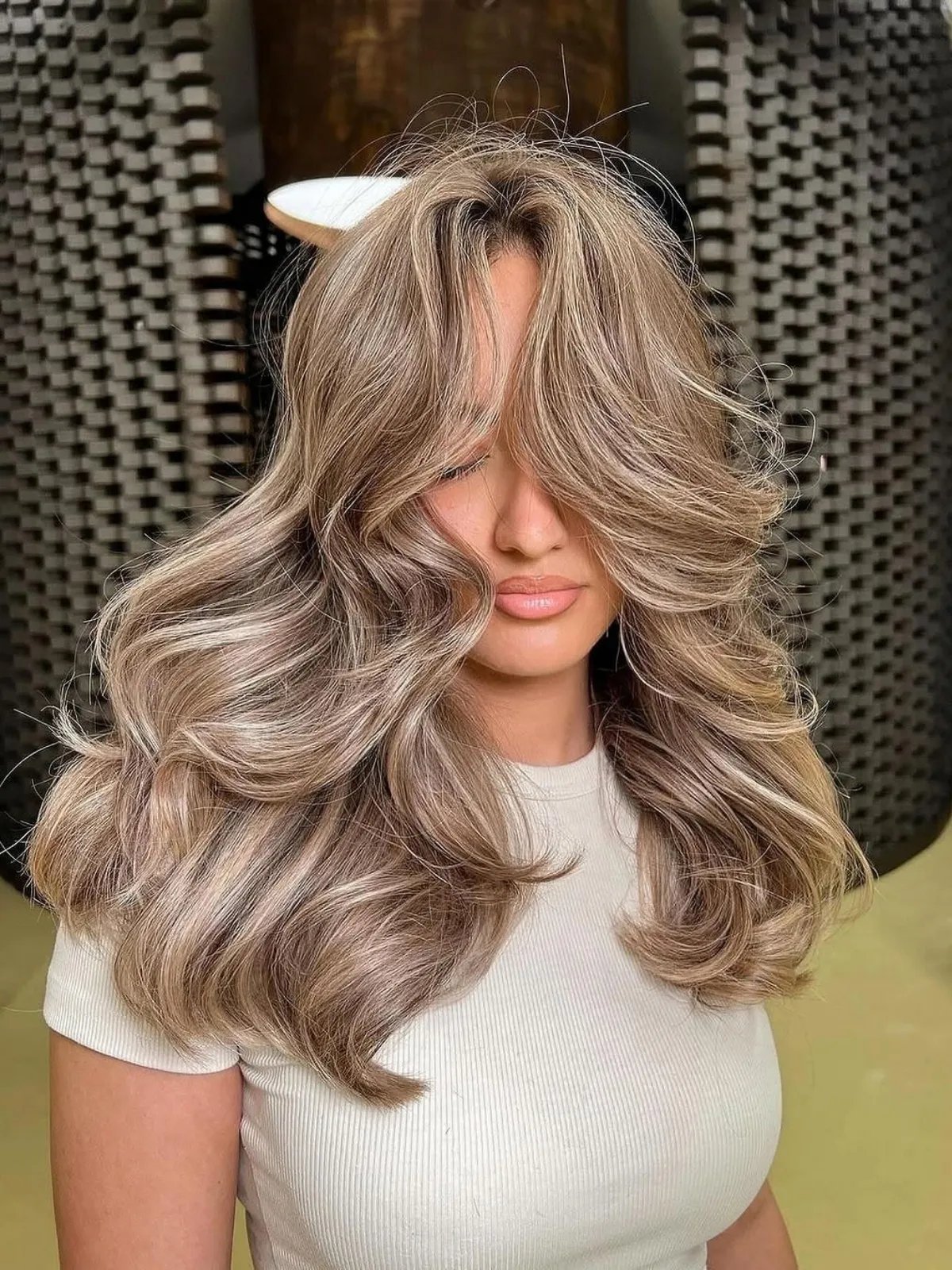 Model with brown hair featuring chunky champagne blonde highlights.