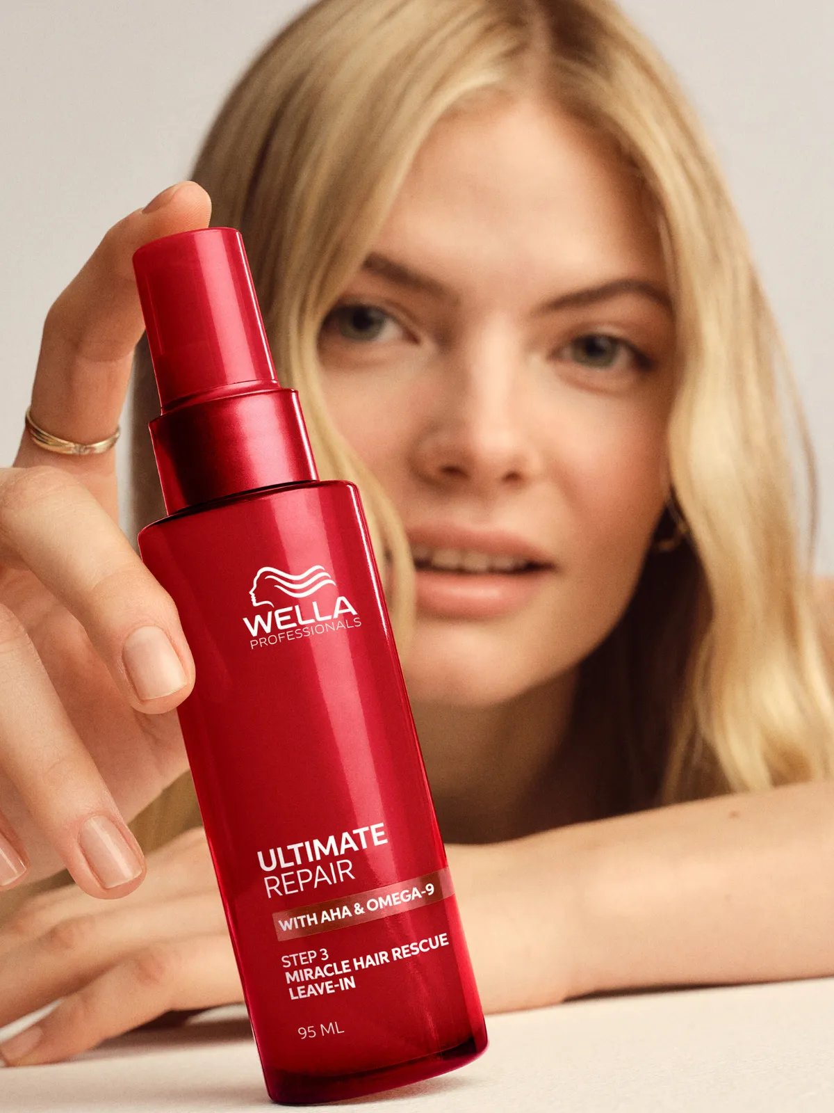 Model holds a bottle of ULTIMATE REPAIR Miracle Hair Rescue.
