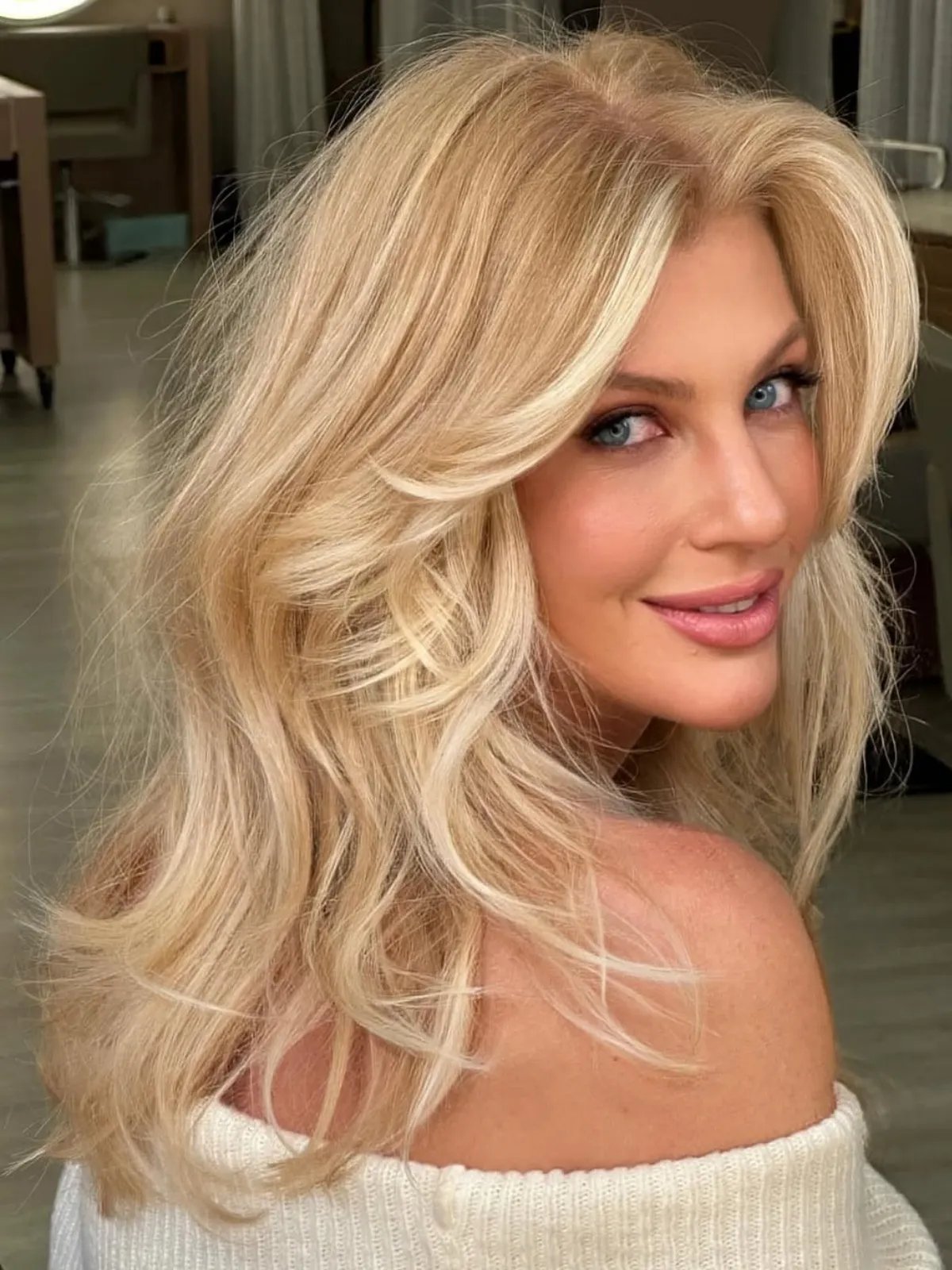 Model with voluminous, bouncy, bright butter blonde hair.