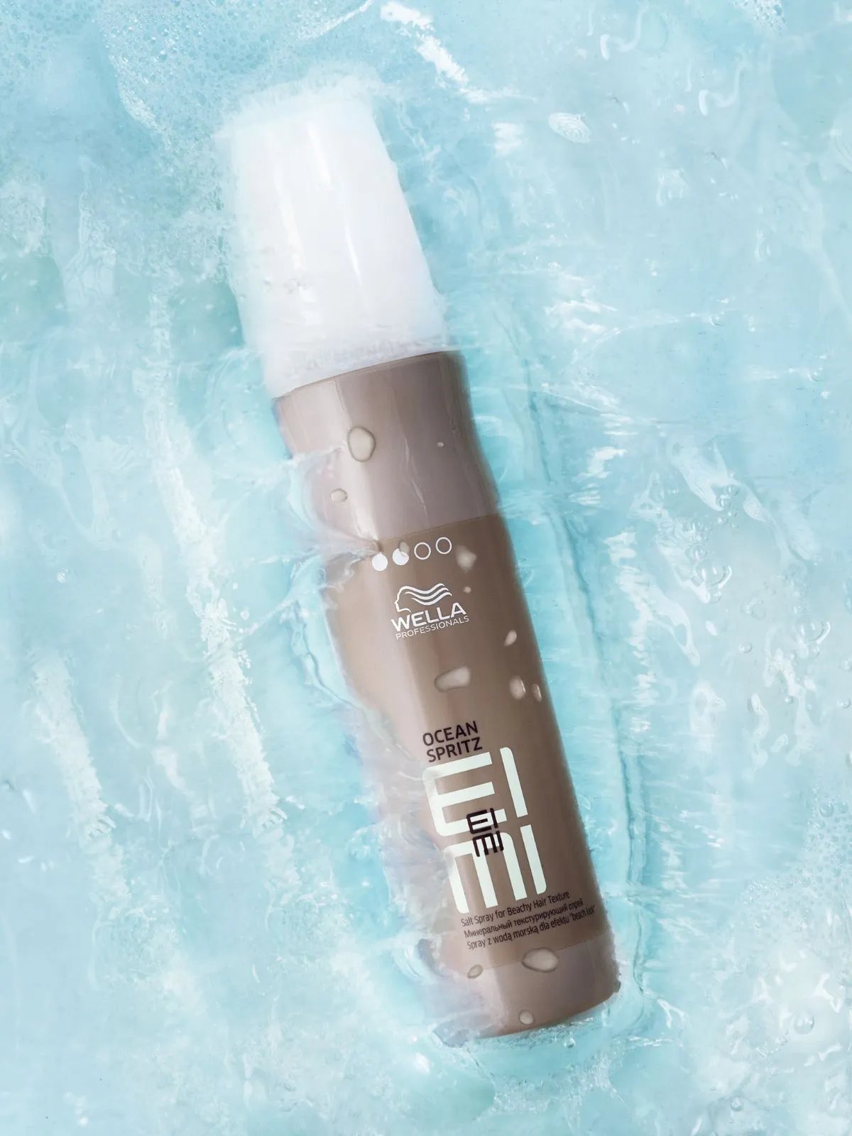 Bottle of EIMI Ocean Spritz floating in water.