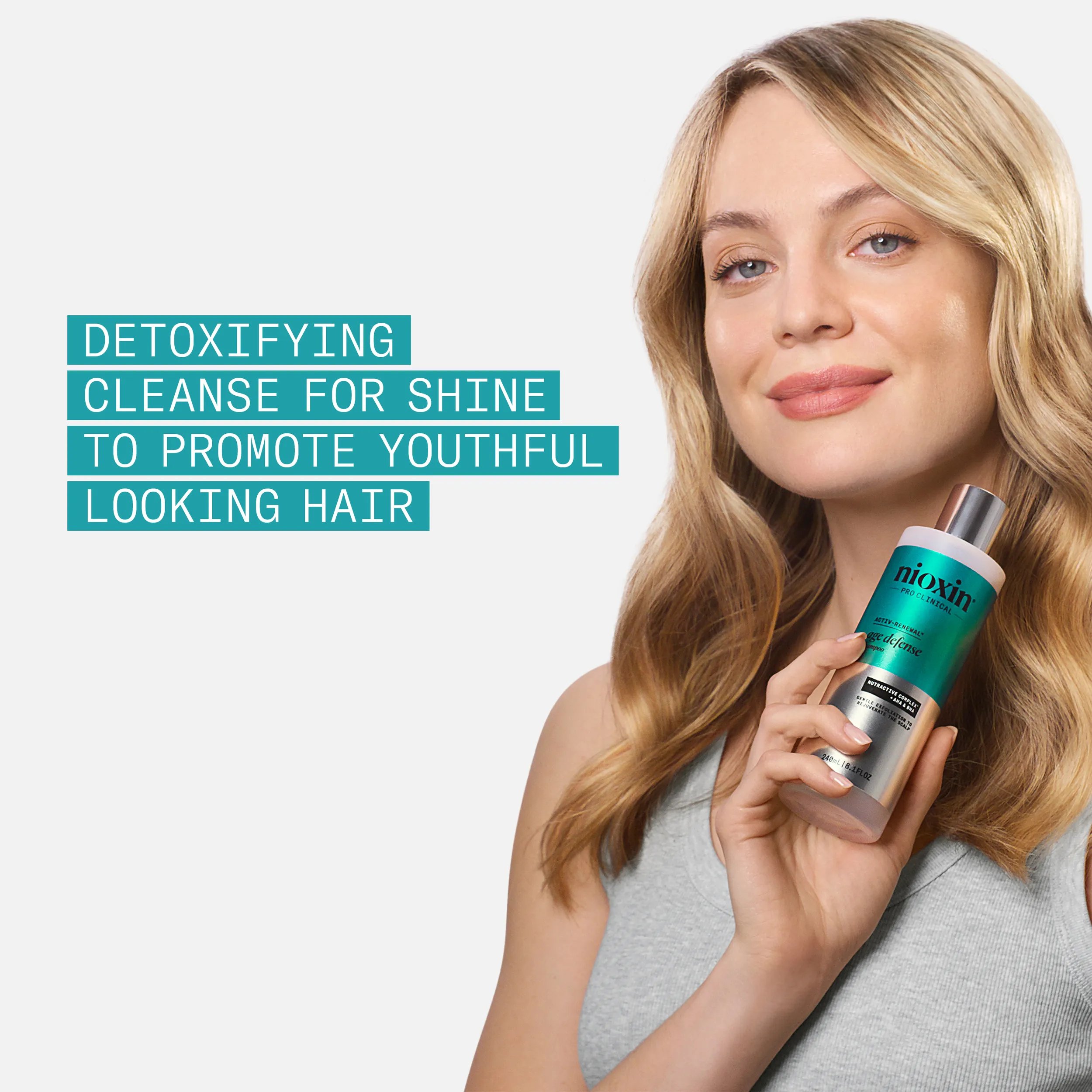 blonde model holding age defense shampoo bottle