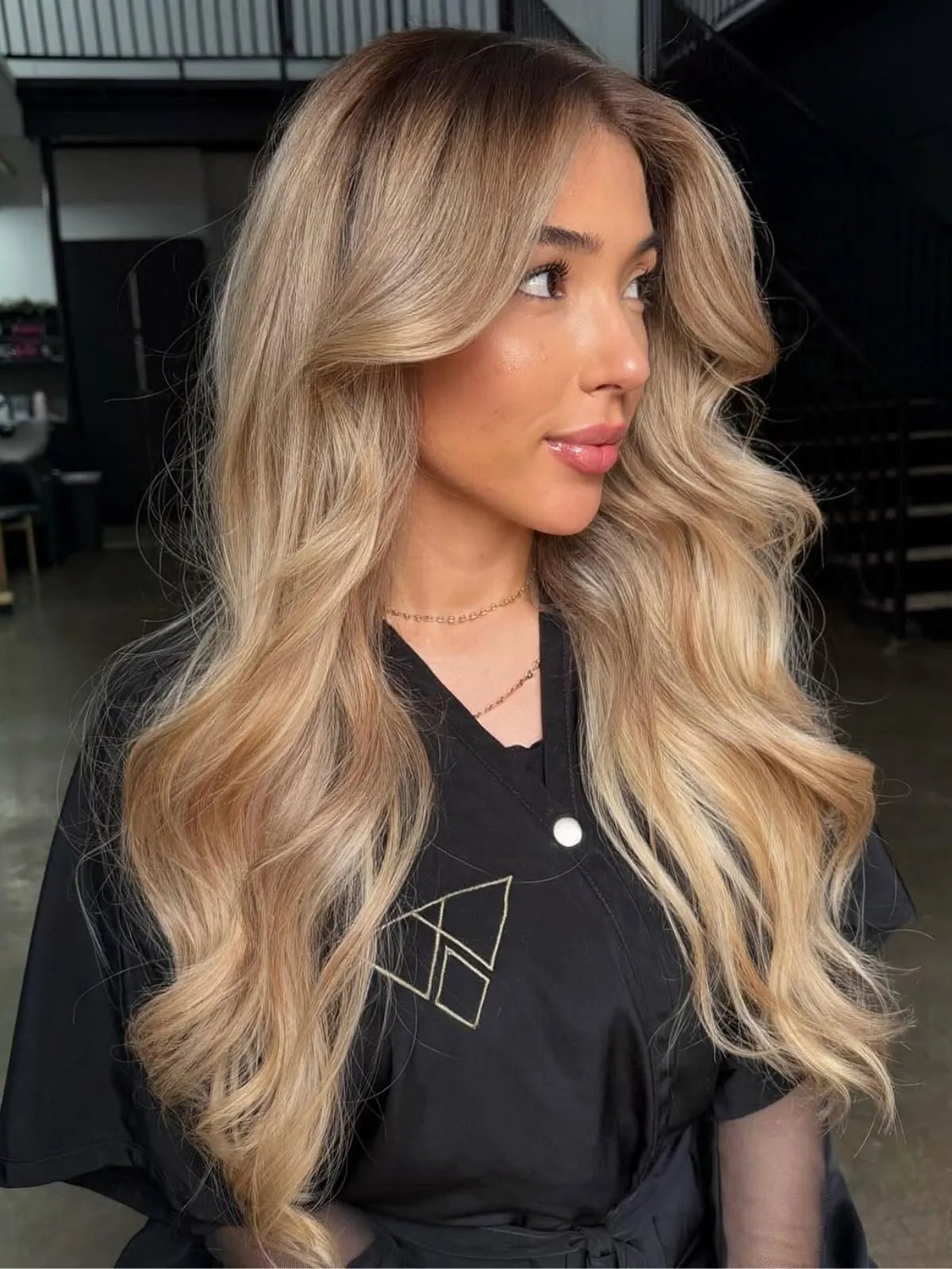 Model with long, loosely curled, buttercream blonde hair.