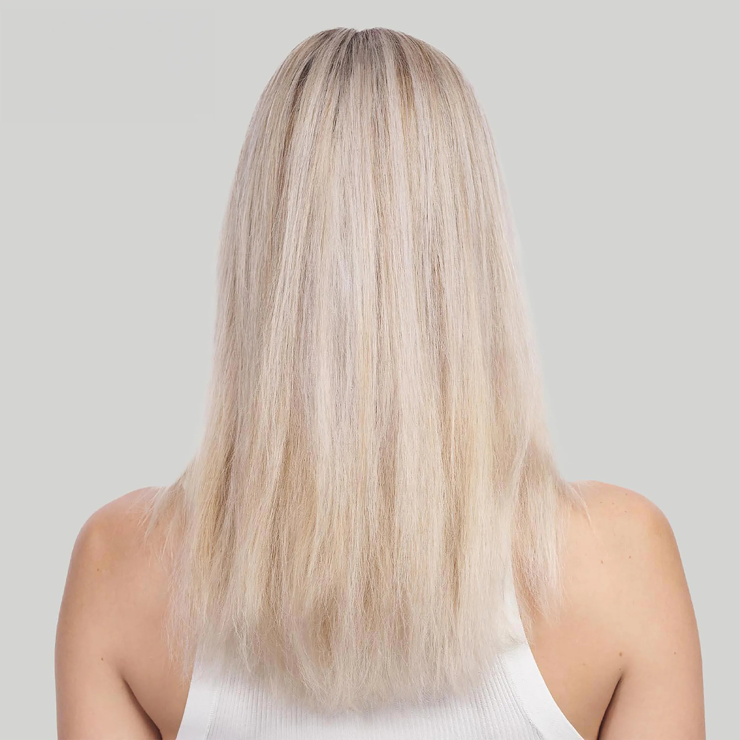 Woman with long blonde hair faces away from the camera. Hair looks dry and damaged. Text reads before with non conditioning shampoo.