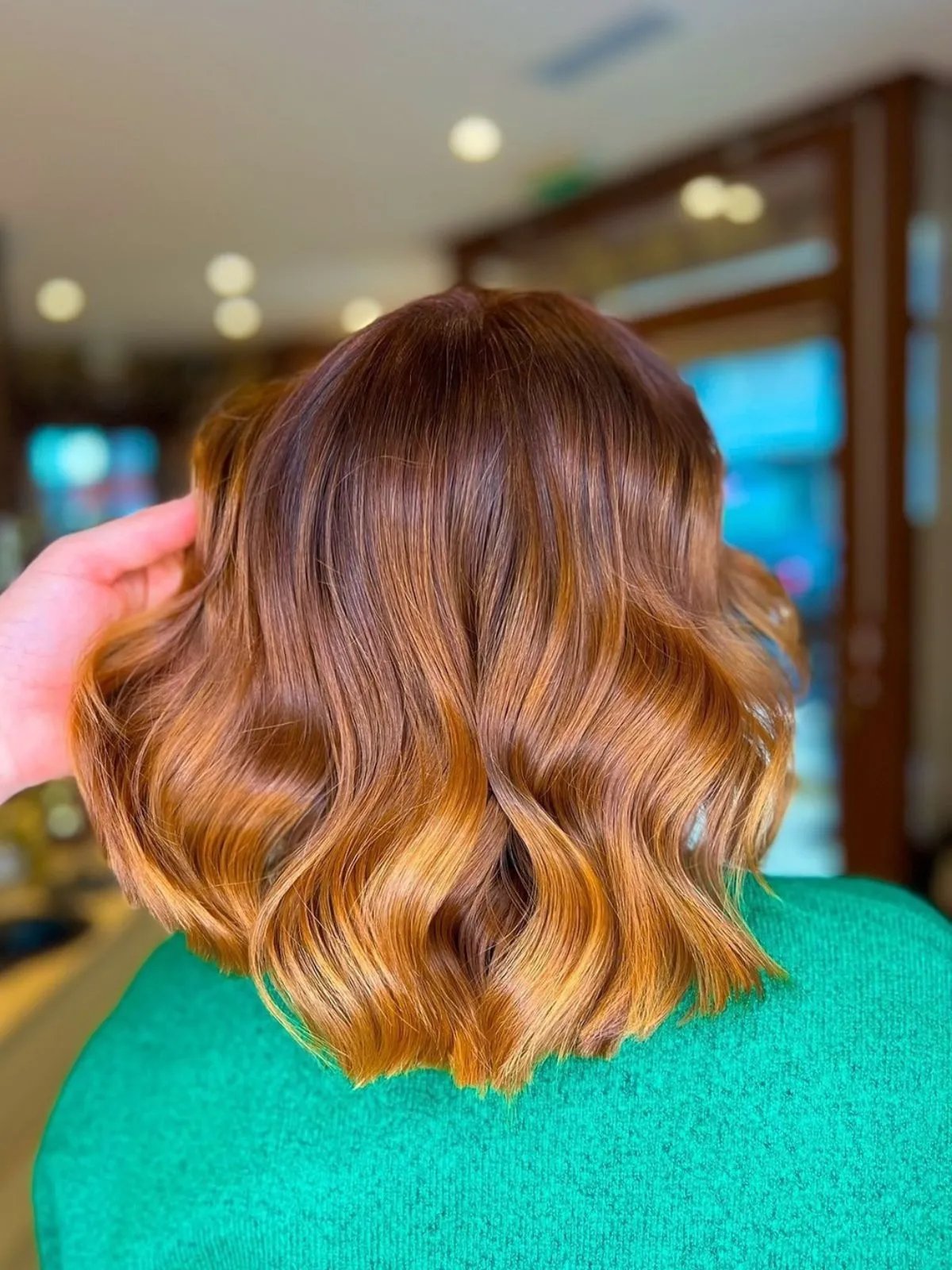 Model with shoulder-length, pumpkin spice-colored hair.
