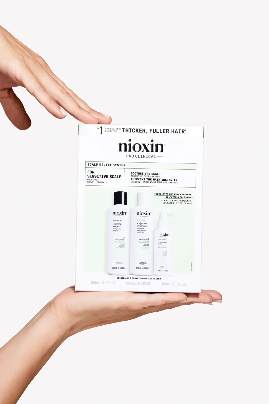 Nioxin Scalp Relief System box sitting in a white hand against white background