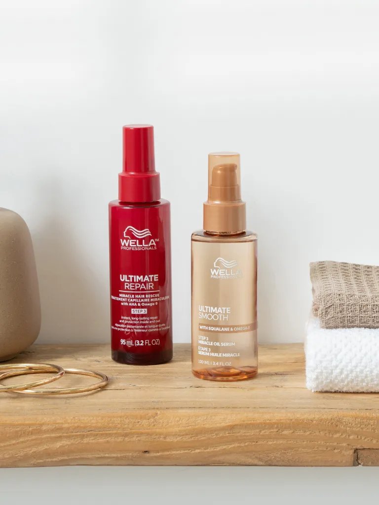 ULTIMATE REPAIR Miracle Hair Rescue and ULTIMATE SMOOTH Miracle Oil Serum on a wooden surface.