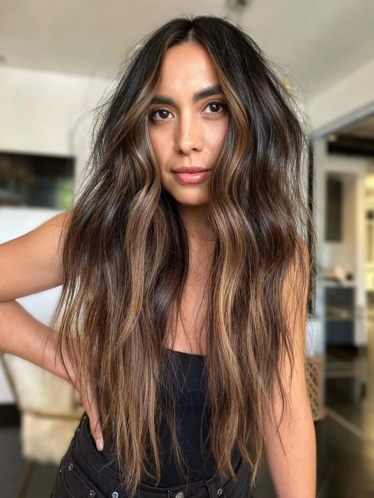 Model with golden mocha brown balayage featuring chunky, radiant highlights for a warm, glowing effect.