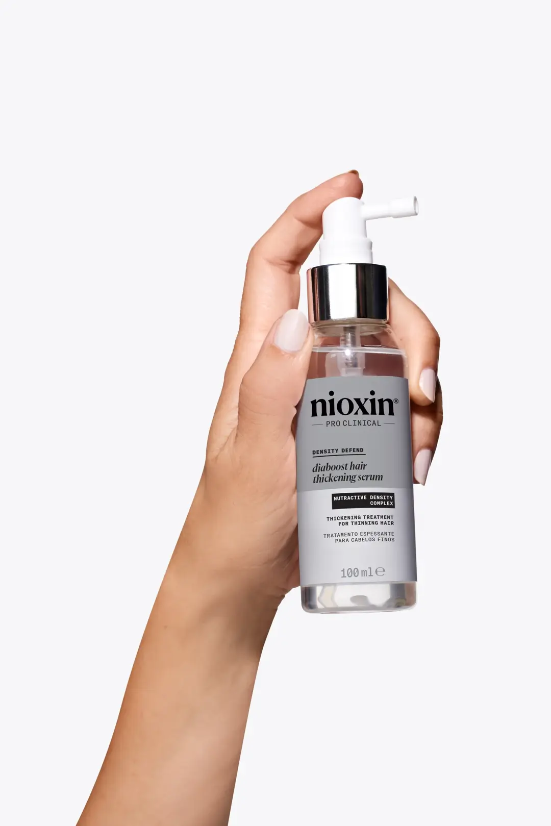 Nioxin Diaboost Hair Thickening Serum in mano su sfondo bianco