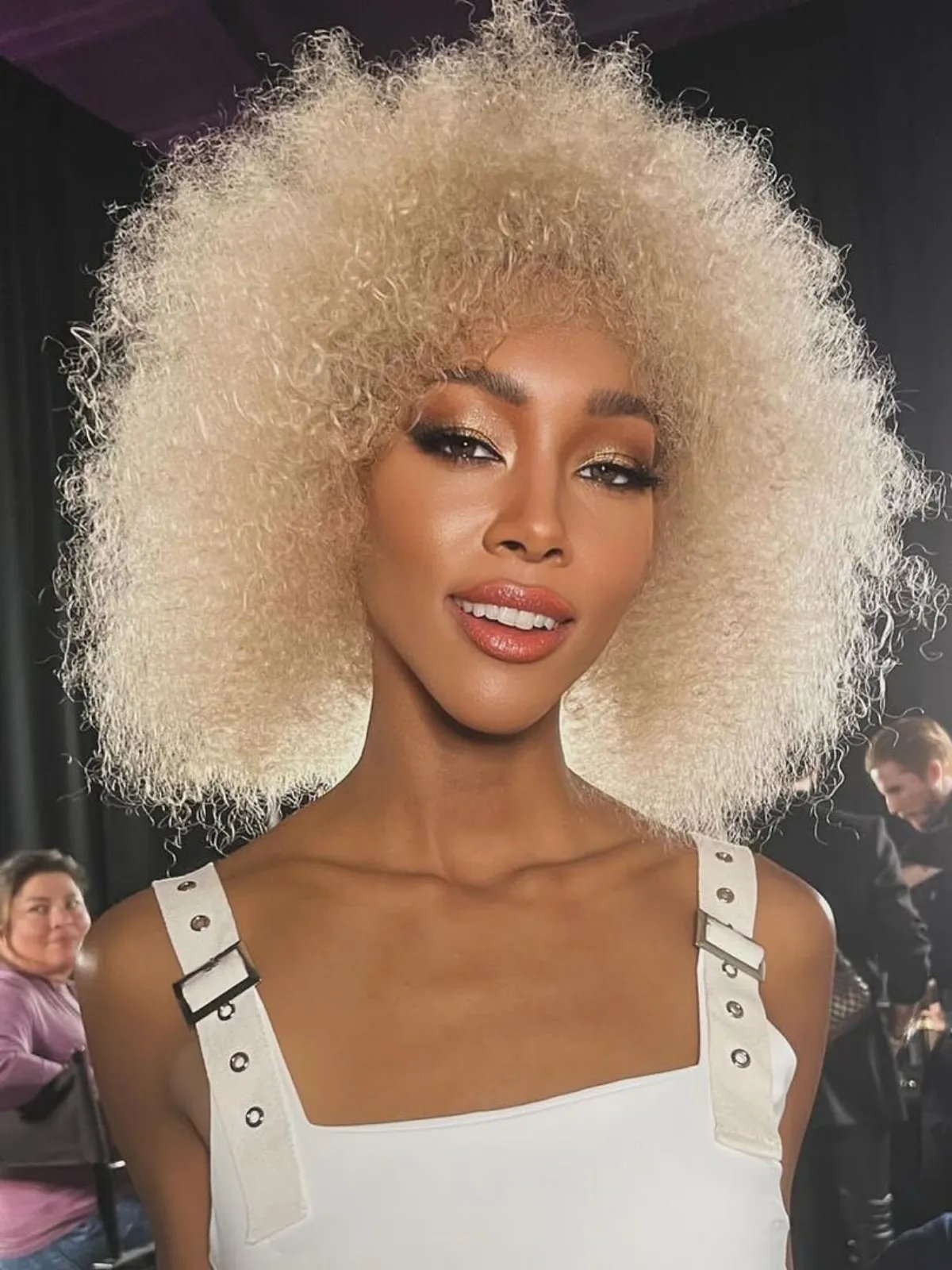 Model with golden platinum blonde curly hair.