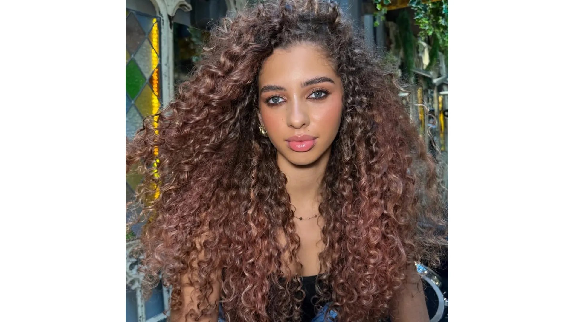 Model with glossy, rose brown, curly hair.