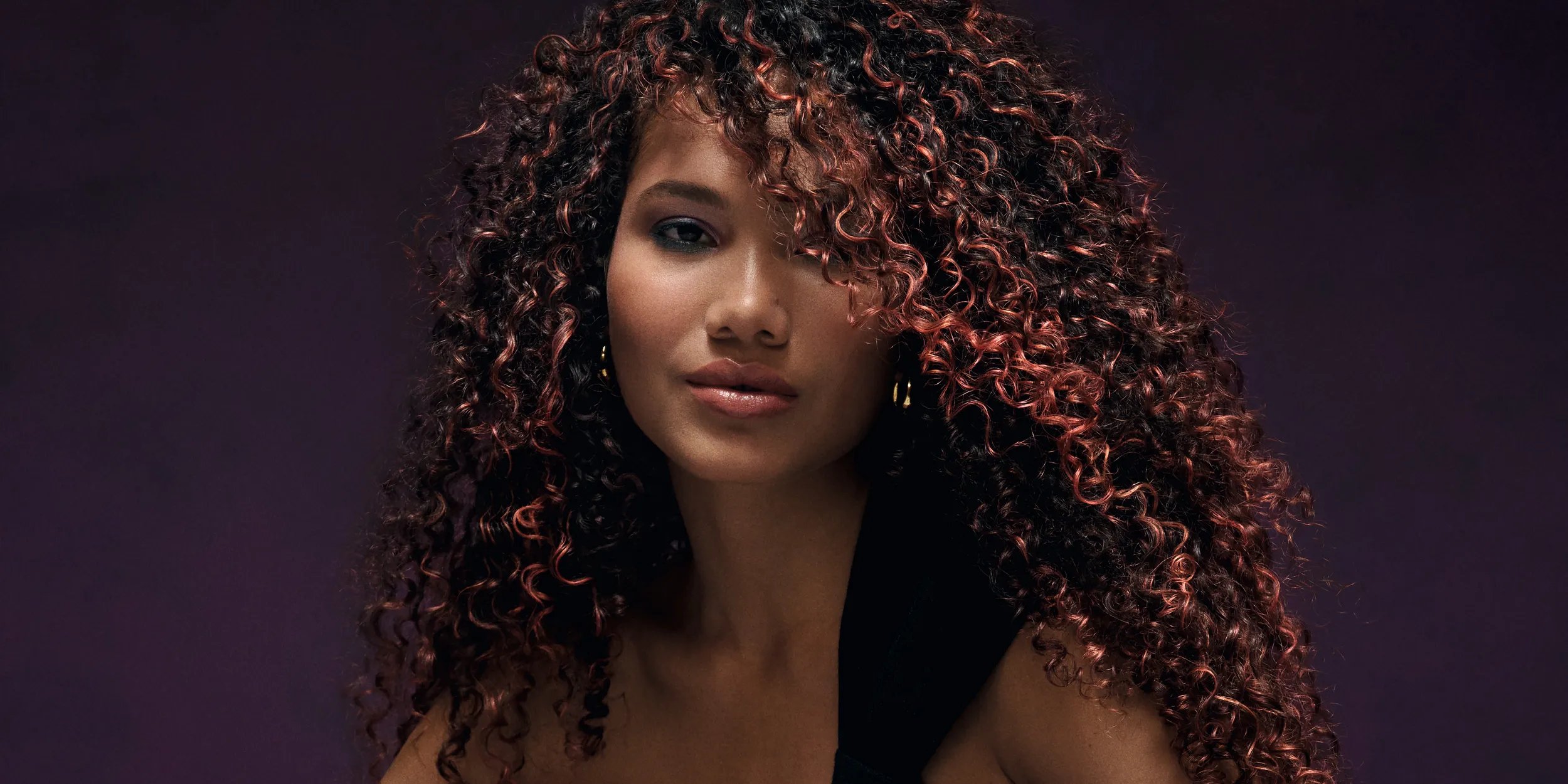Model with long, brown hair, featuring sweeps of maroon red.