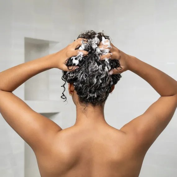 ULTIMATE SMOOTH Shampoo is massaged into wet hair.