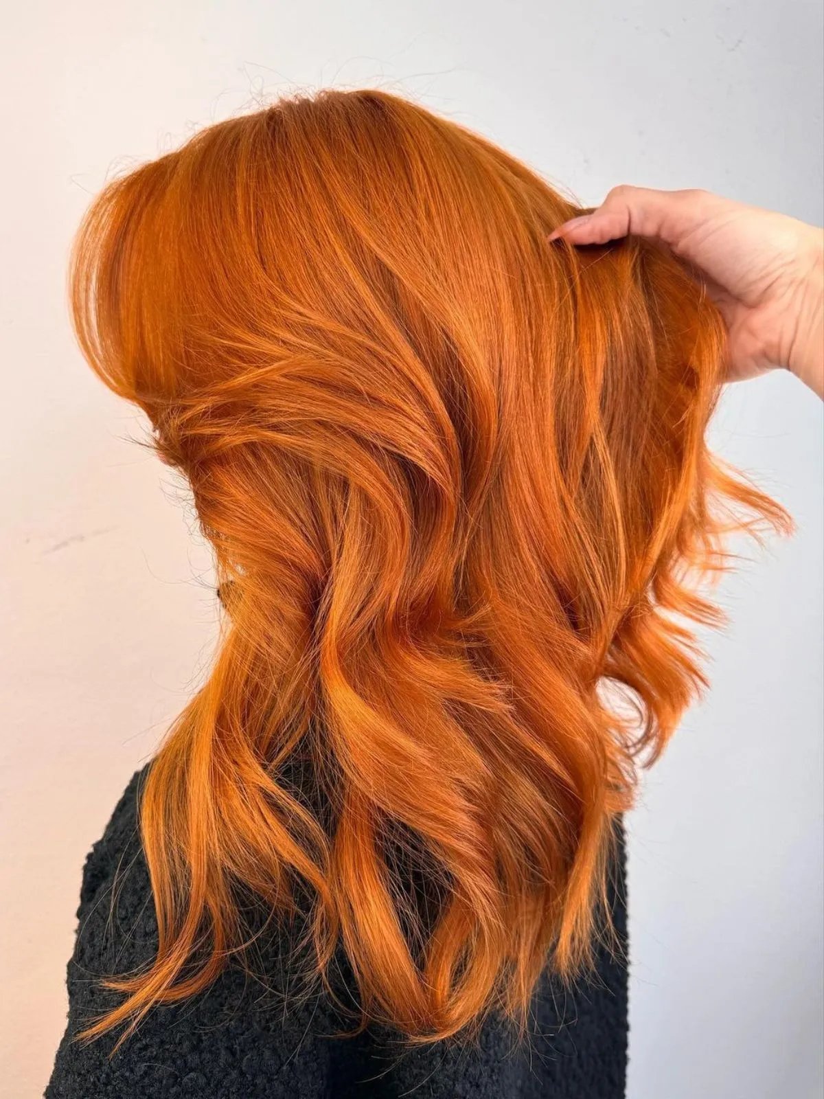 Model with long, tousled, vibrant ginger hair.