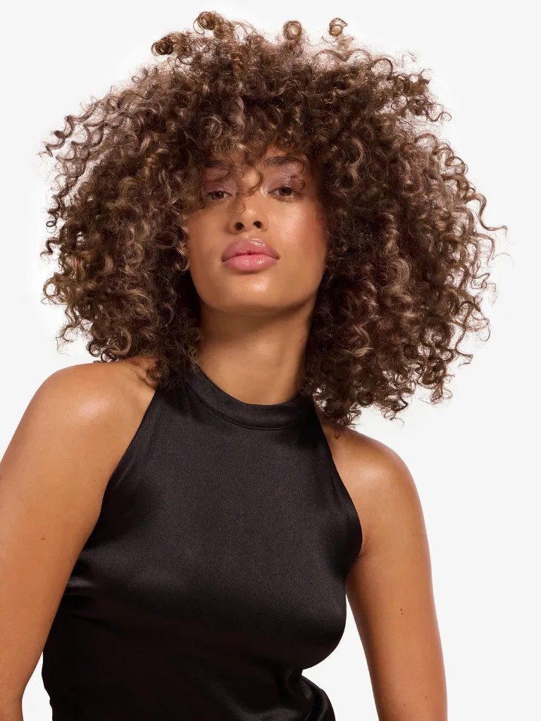 Model with full, voluminous, curly bronde hair.