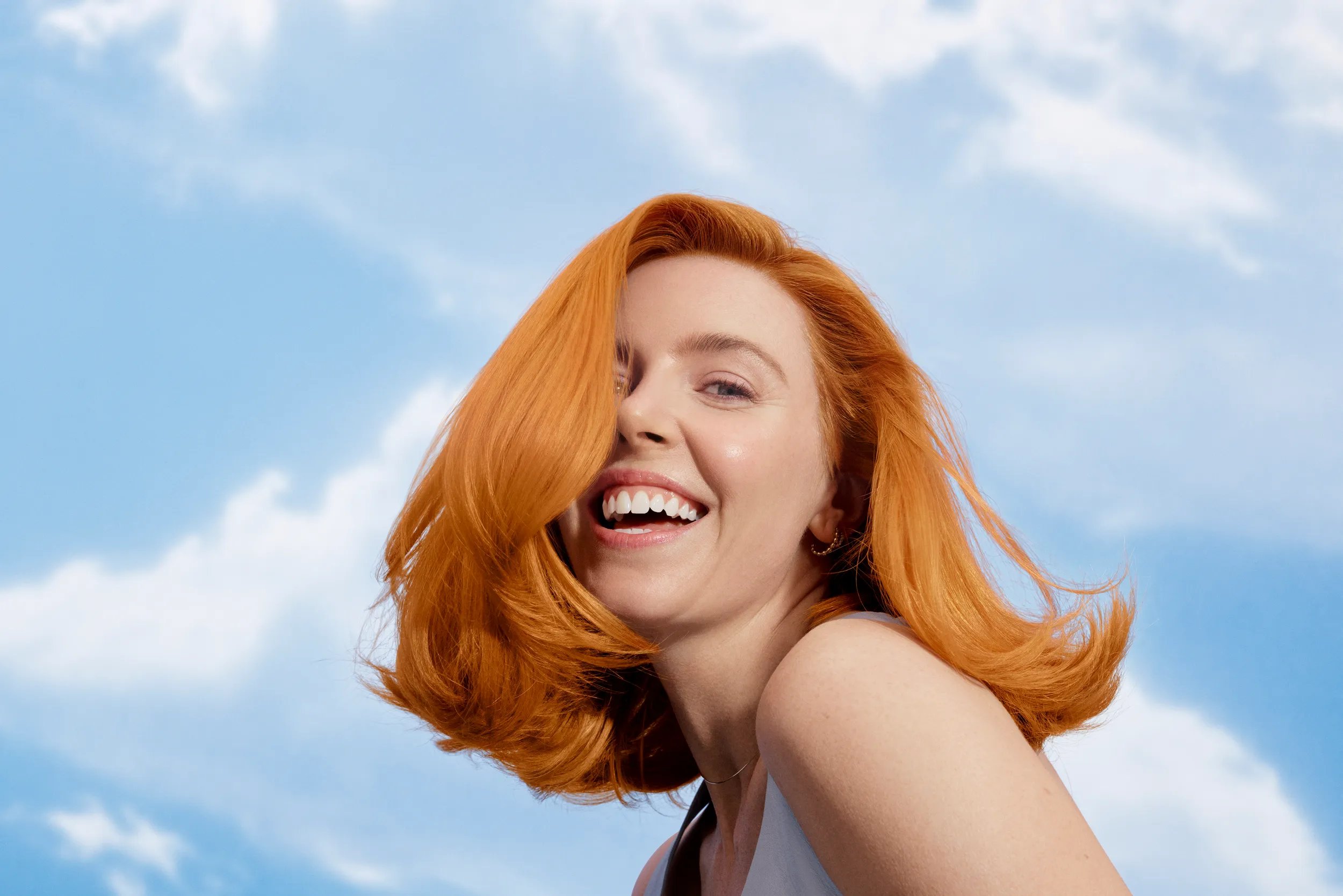 Stacey Dooley with copper hair flowing against the sky