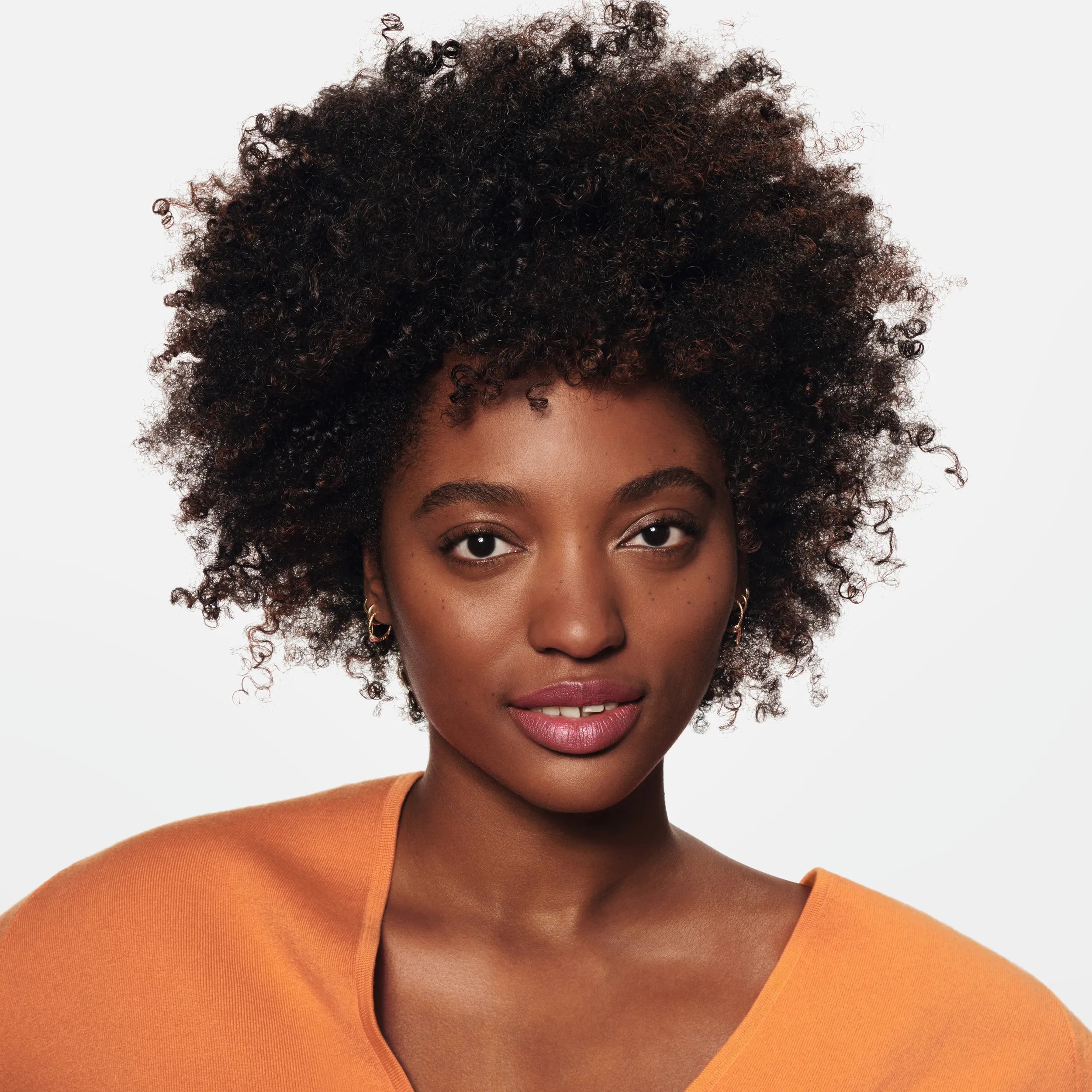 Foto di una giovane modella con capelli Afro sani, strettamente attorcigliati, con un testo sovrapposto che dice 'Nutrimento immediato'.