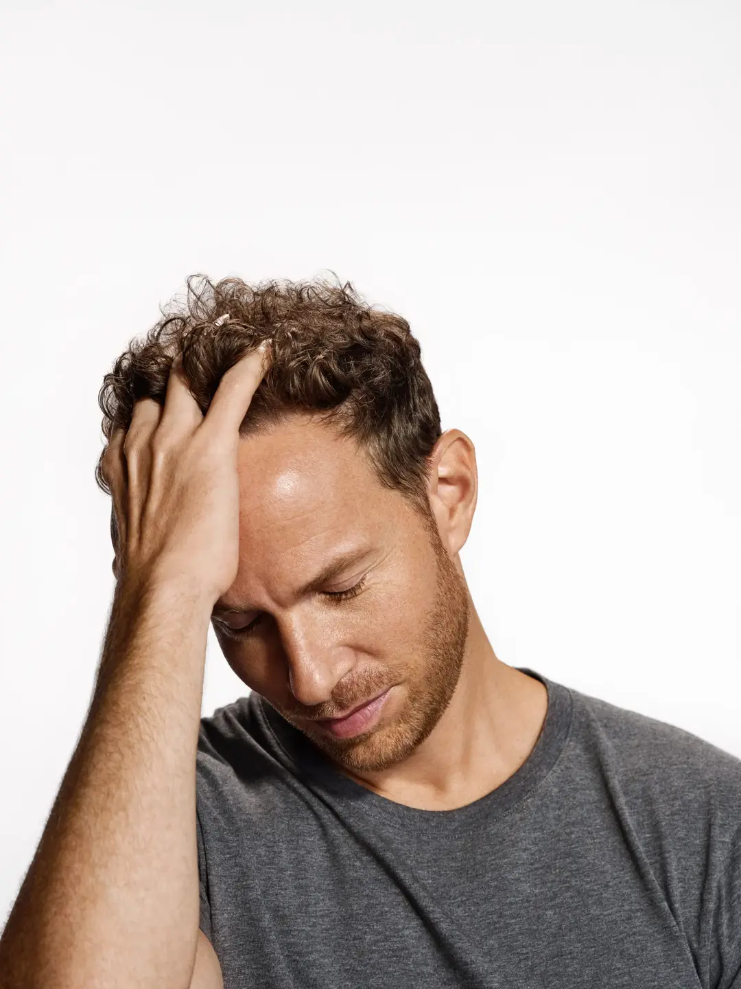 man running fingers through brown curly hair