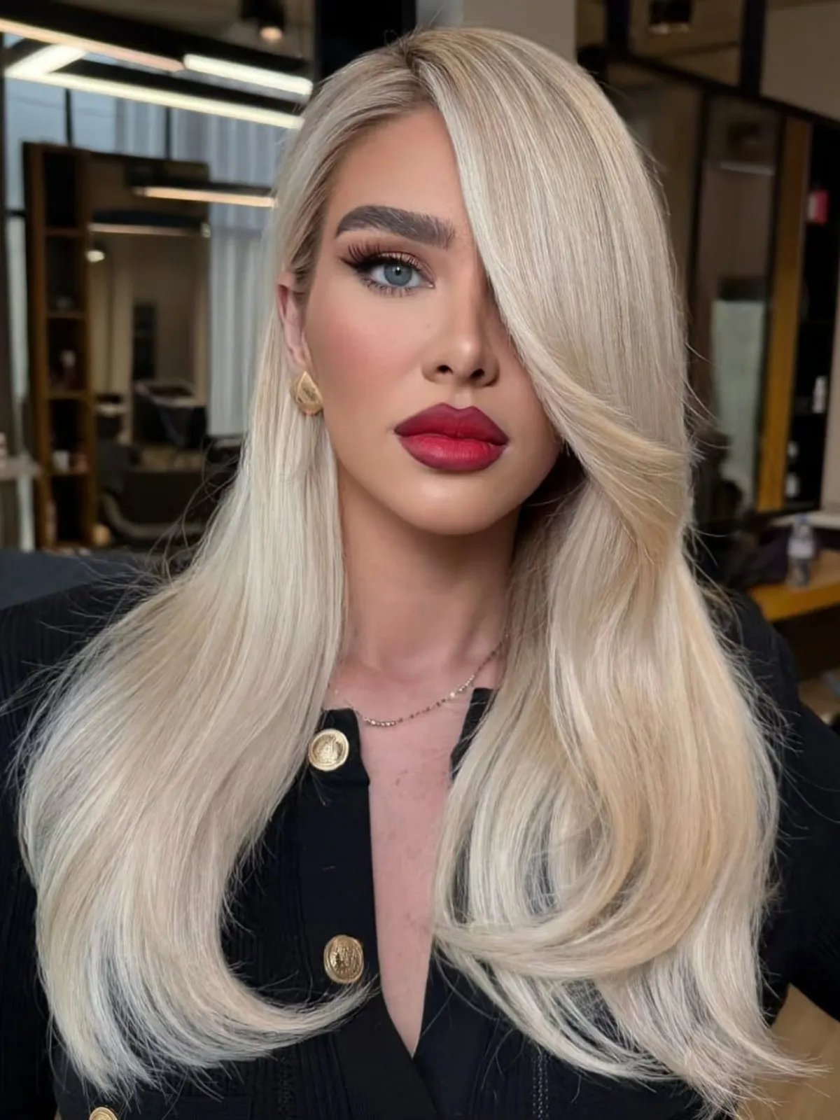 Model with pearlescent, old money blonde hair, styled super sleek and glossy.