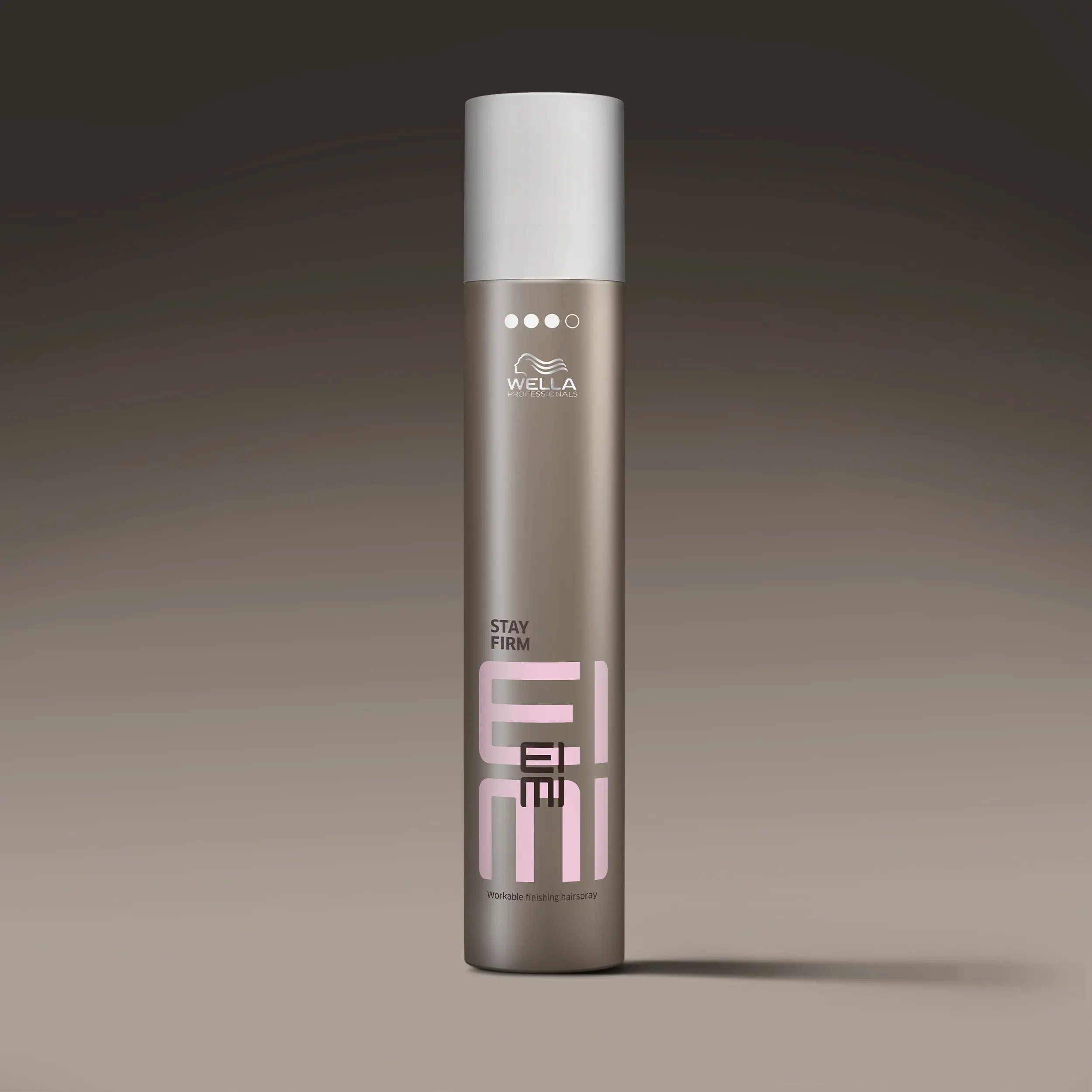 Image shows a bottle of Wella EIMI Stay Firm hairspray against a gradient gray background.