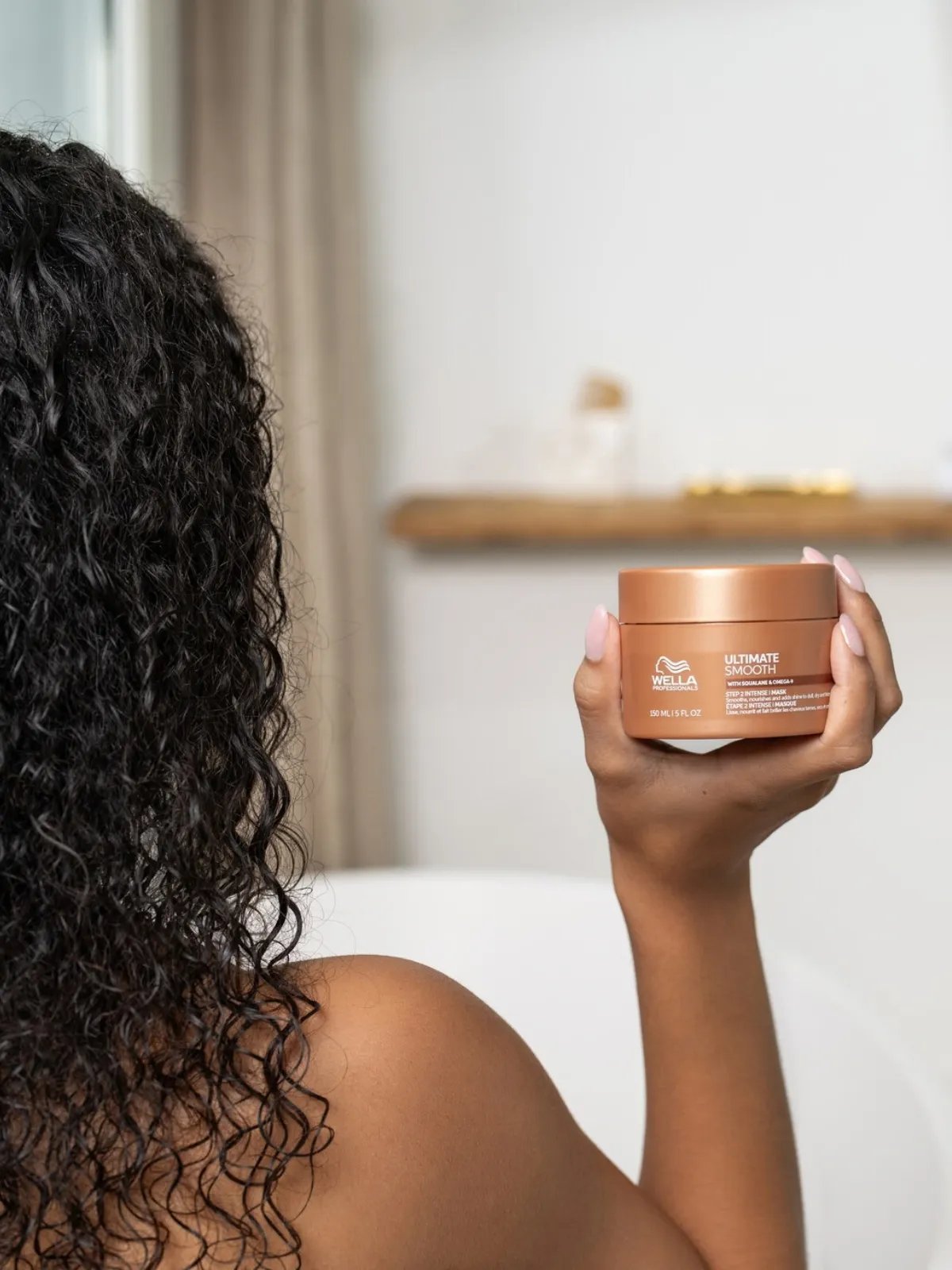 Model holds a jar of ULTIMATE SMOOTH Intense Mask.