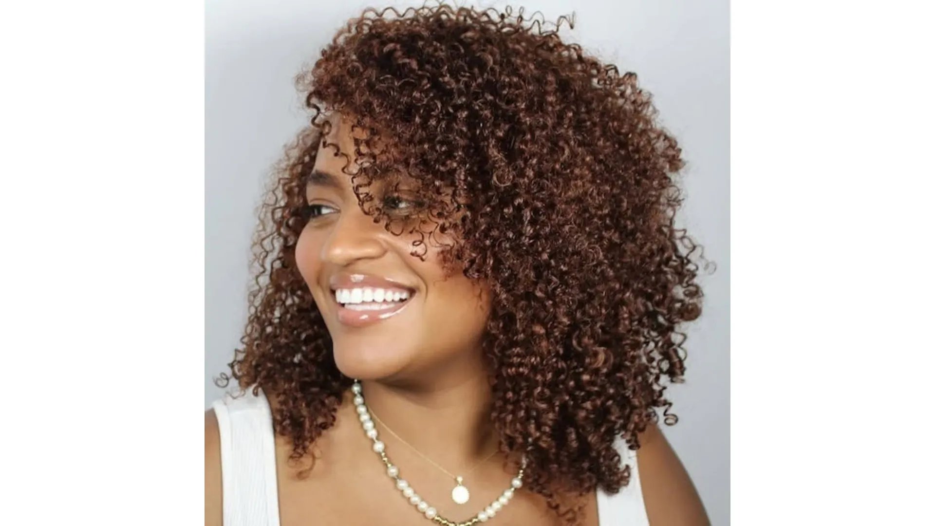 Model with super-glossy, dark brown, curly hair.