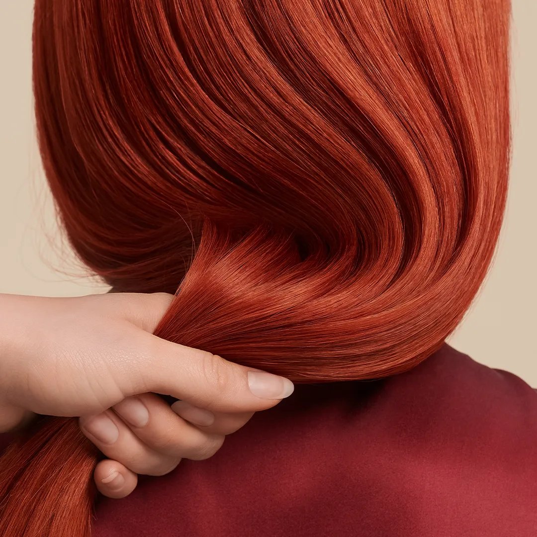 Back view close up shot of a woman's hair in copper red color.