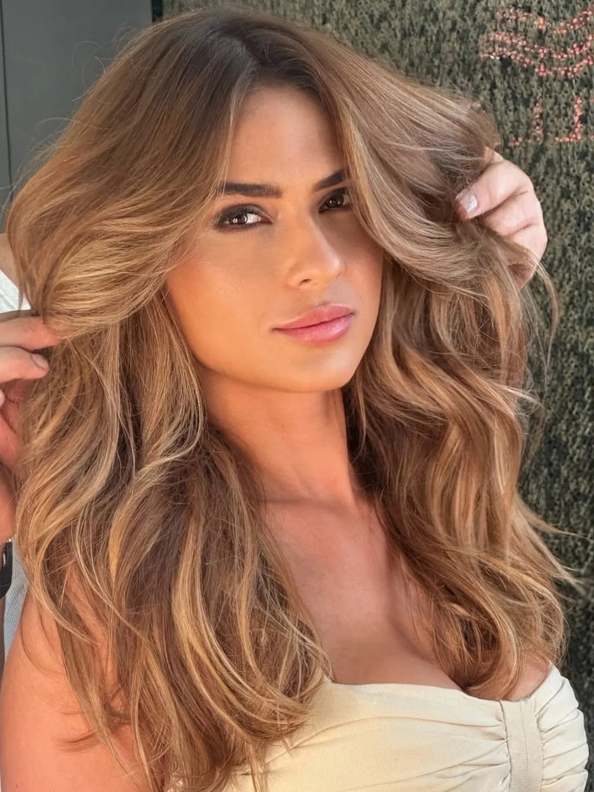 Model with bronzy tones through a dark blonde and brown balayage.