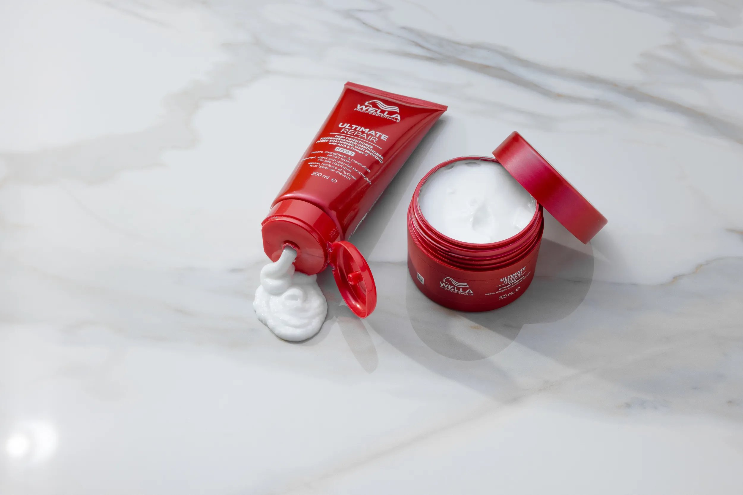 ULTIMATE REPAIR Conditioner and ULTIMATE REPAIR Mask on a marble surface.