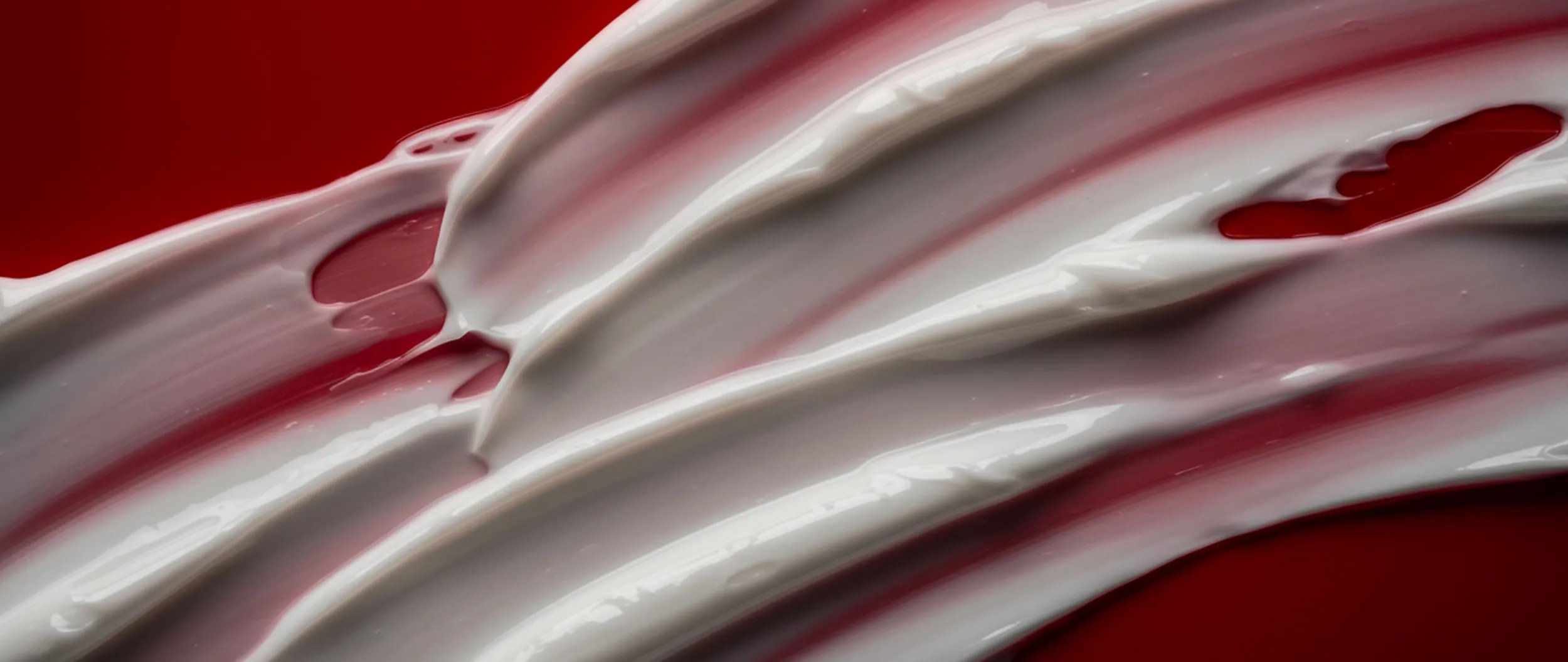 Cream smear on a red background.