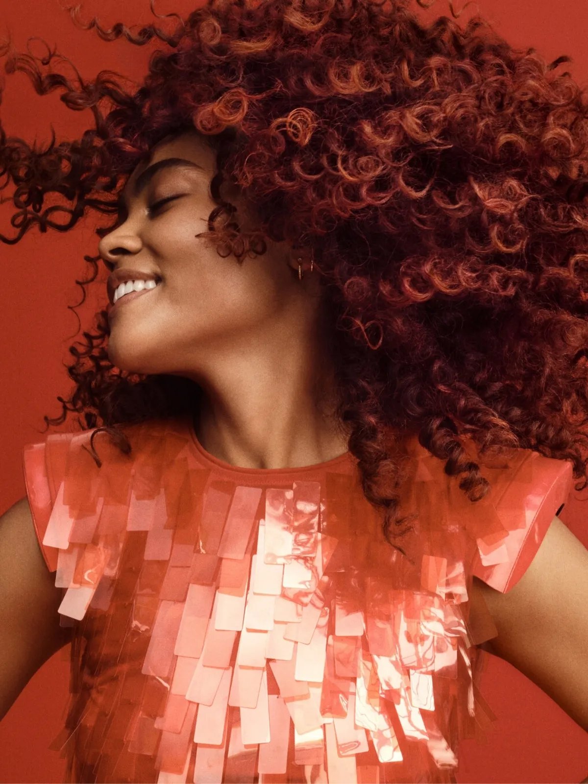 Model swishes their healthy, curly hair.