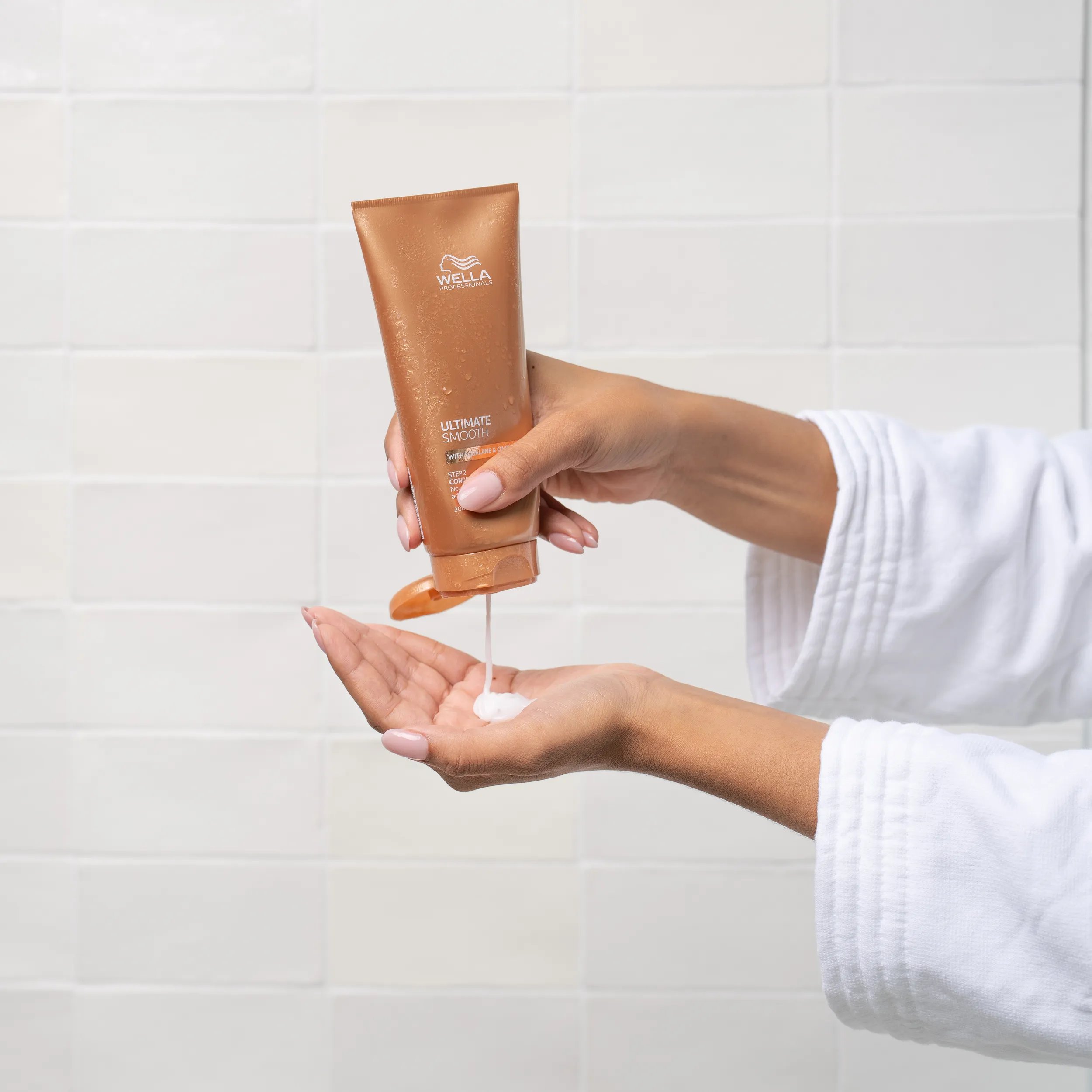 Model squeeze ULTIMATE SMOOTH Conditioner into hand.