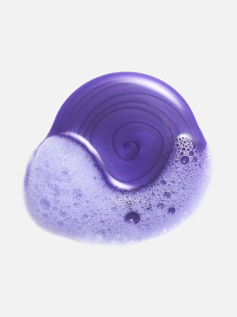 Drop of purple shampoo on a white background.