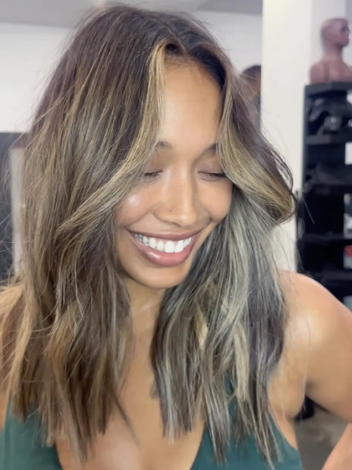 Caramel brown hair with a dark root melt and radiant bronde mid-length highlights.
