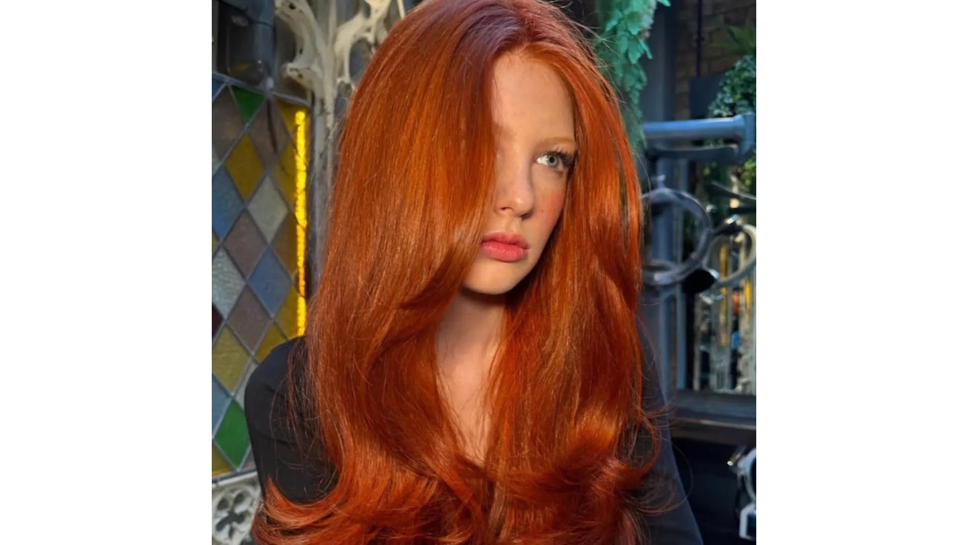 Model with bright ginger hair styled in a glossy blow-dry.