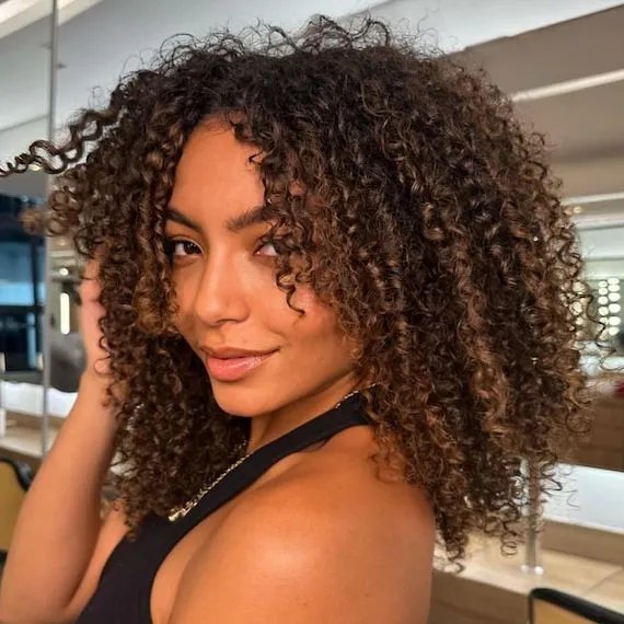 Model with dark brown, beautifully defined curls.