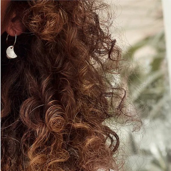 Close-up of model’s brown, curly hair.